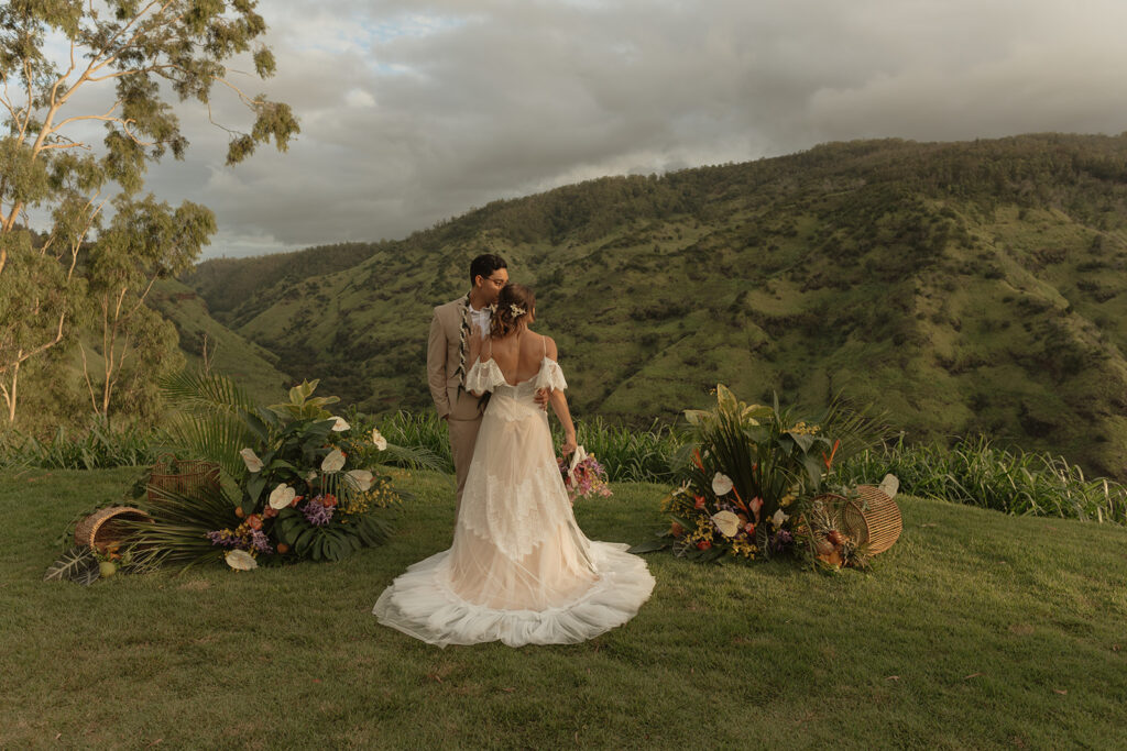 Wedding ceremony with green mountains in the background at Waialua Valley Farms