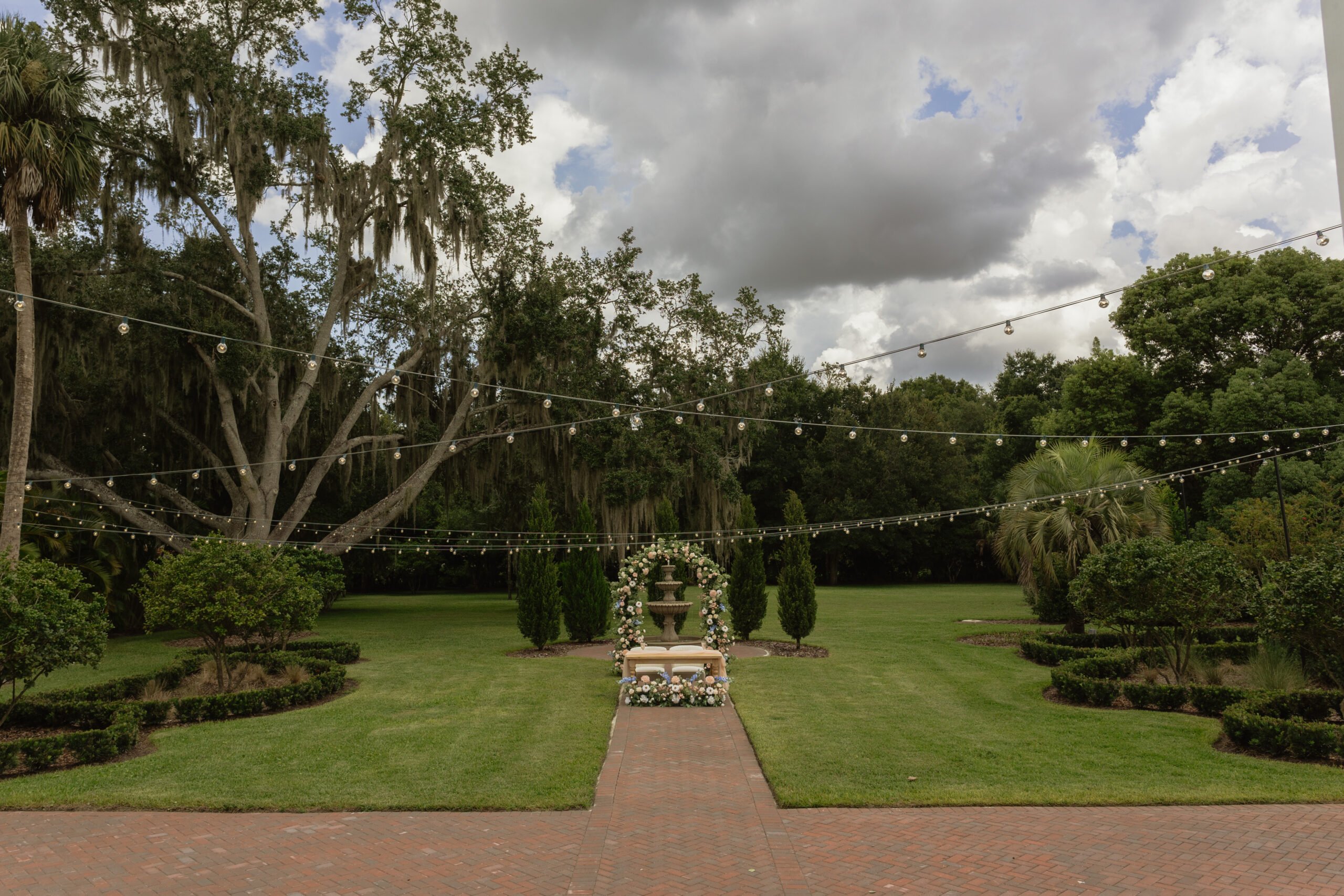 Romantic backyard wedding at The Palm Mansion in Umatilla, Florida with lush palm trees and floral arch